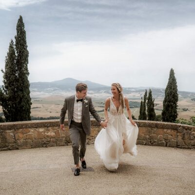 Bride and groom running together while holding hands during their grand Italian elopement, shot by Blitzkneisser