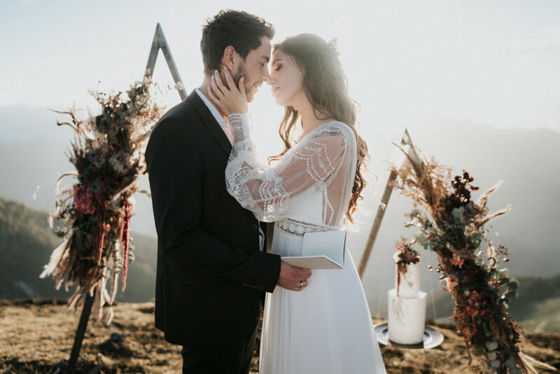 How to Plan The Perfect Mountain Elopement + Locations: Bride and groom wrapping their arms around each other during their mountain elopement, shot by Blitzkneisser